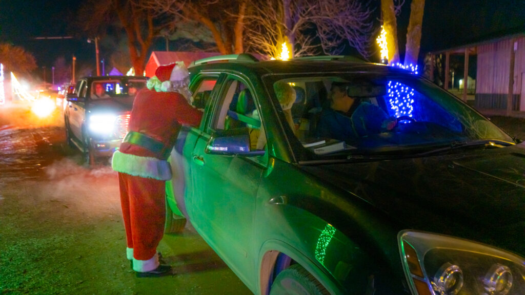 Santa talking to a car of people at holiday light display